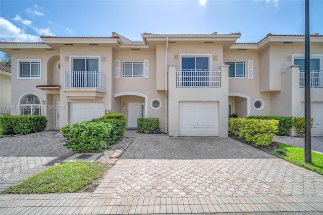 view of front of home with a garage and a balcony