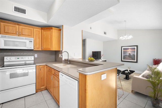 kitchen with white appliances, a chandelier, light tile patterned floors, kitchen peninsula, and sink