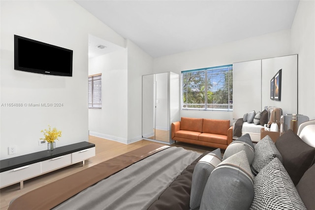 bedroom with vaulted ceiling and light hardwood / wood-style floors