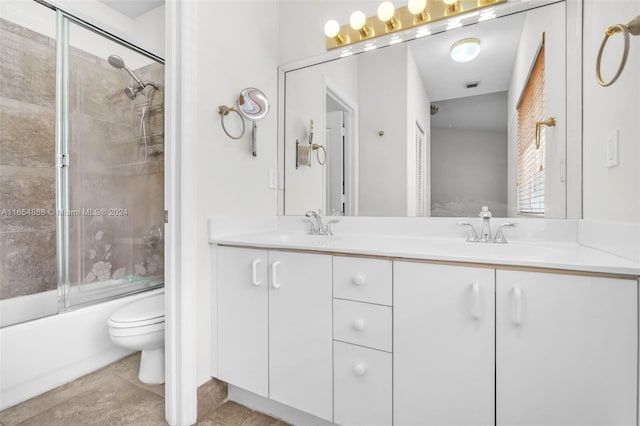 full bathroom featuring tile patterned floors, toilet, combined bath / shower with glass door, and vanity