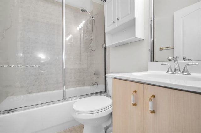 full bathroom with shower / bath combination with glass door, vanity, toilet, and tile patterned flooring