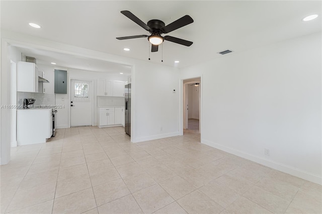 unfurnished living room featuring light tile patterned flooring, electric panel, and ceiling fan