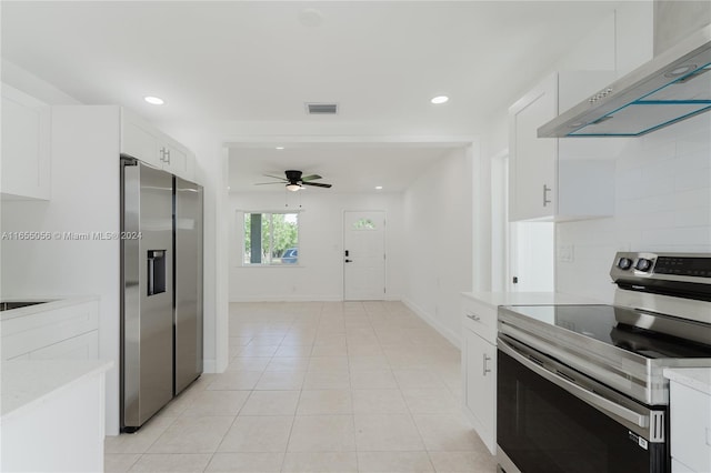 kitchen featuring light tile patterned floors, stainless steel appliances, exhaust hood, ceiling fan, and white cabinets