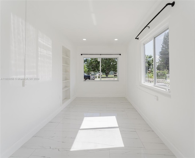 empty room featuring a wealth of natural light and built in features