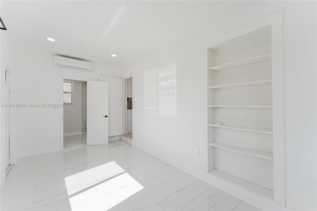 unfurnished room featuring a wall unit AC