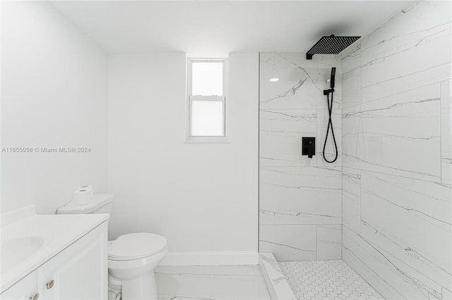 bathroom with vanity, toilet, and a tile shower