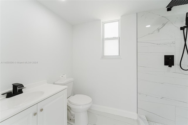 bathroom featuring tiled shower, toilet, and vanity