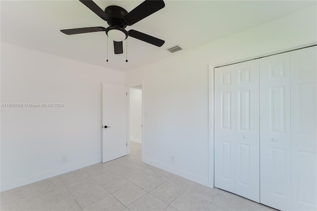 unfurnished bedroom featuring light tile patterned floors, ceiling fan, and a closet