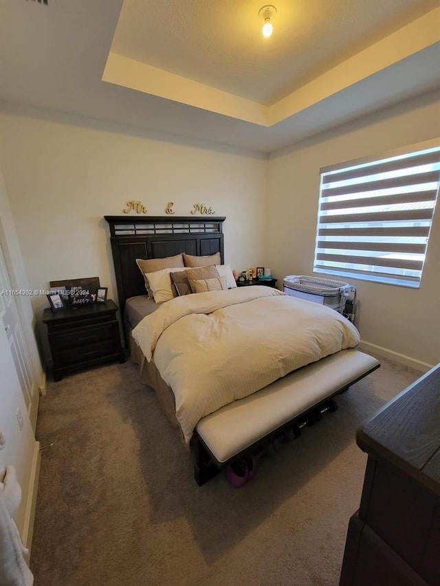 bedroom featuring carpet flooring, baseboards, and a tray ceiling