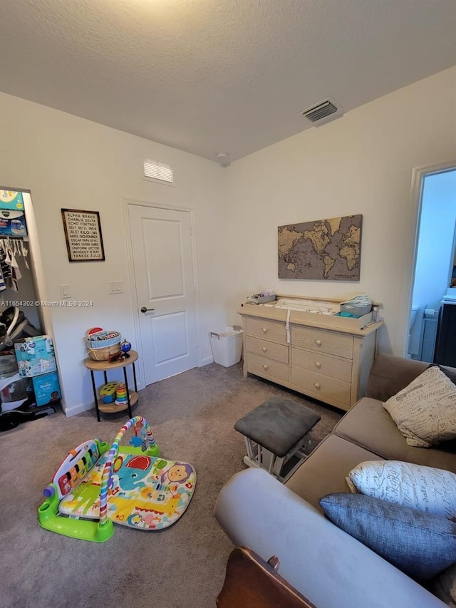 interior space with carpet flooring, a textured ceiling, and visible vents