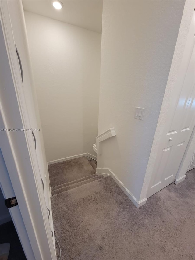 staircase featuring carpet flooring and baseboards