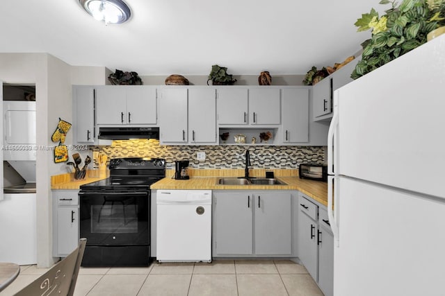 kitchen featuring decorative backsplash, white appliances, sink, and light tile patterned floors