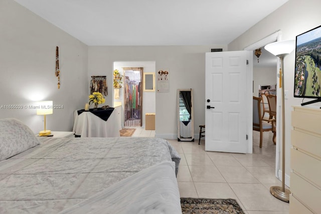 tiled bedroom featuring a walk in closet