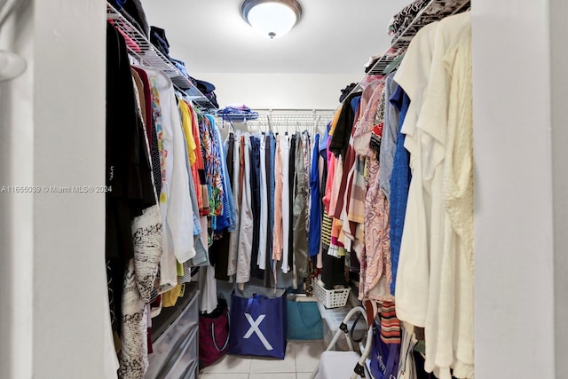 walk in closet with light tile patterned floors