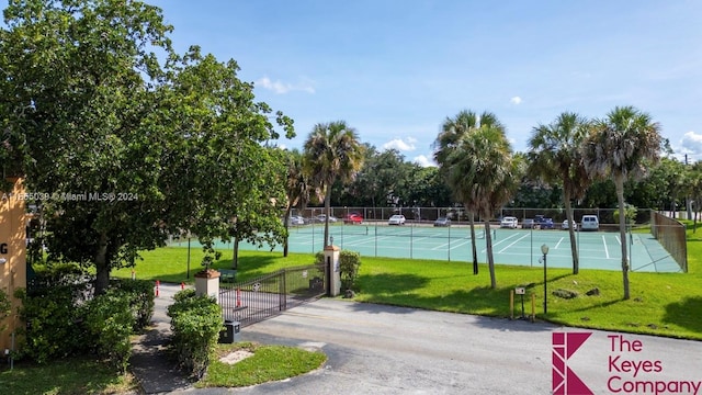 view of home's community featuring tennis court and a yard