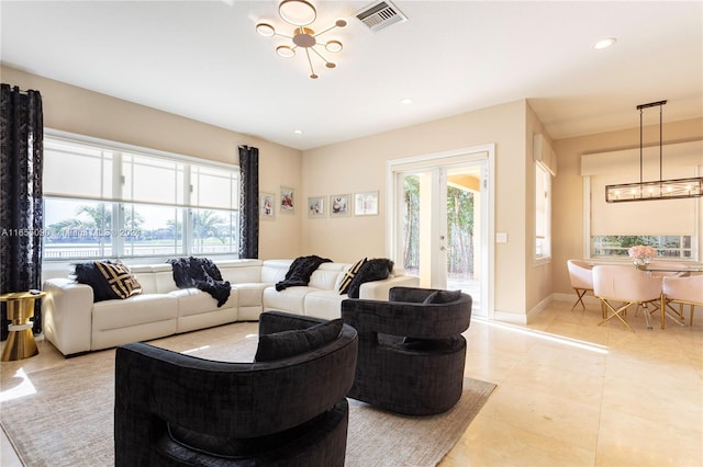 living room featuring a notable chandelier, light tile patterned floors, and french doors