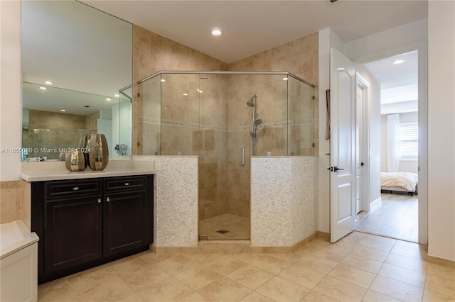 bathroom featuring tile patterned flooring, an enclosed shower, and vanity