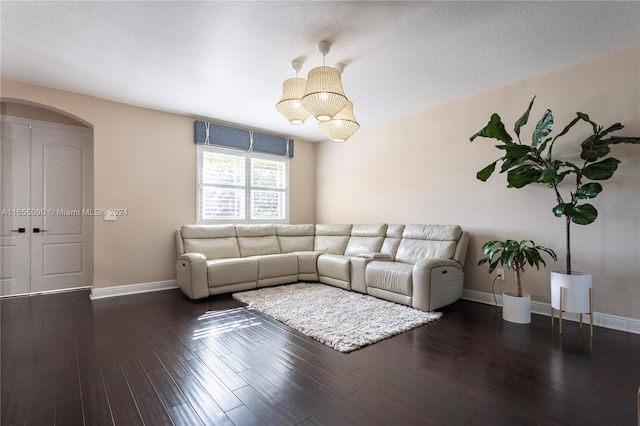 unfurnished living room with dark hardwood / wood-style floors, an inviting chandelier, and a textured ceiling