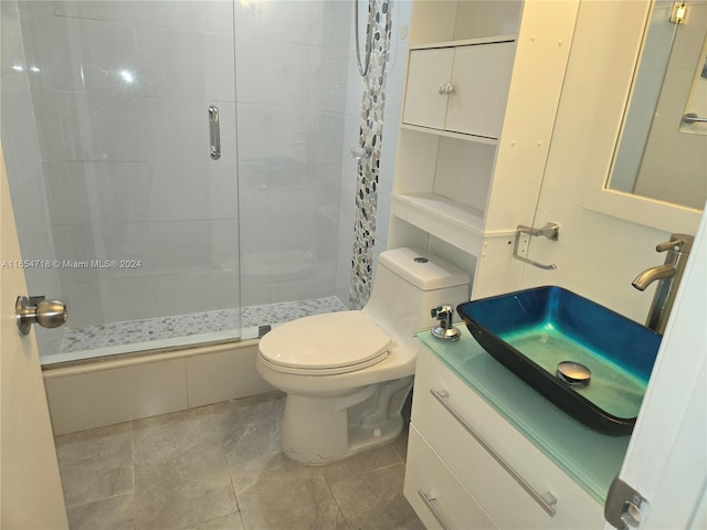 bathroom featuring an enclosed shower, tile patterned flooring, toilet, and vanity