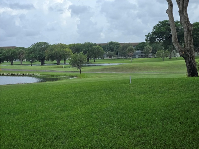 view of property's community with a water view and a yard