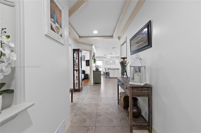 corridor featuring ornamental molding and light tile patterned floors