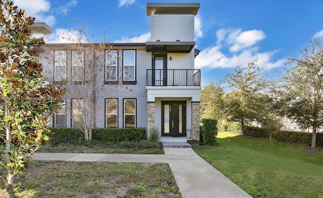 view of front facade featuring a balcony and a front yard