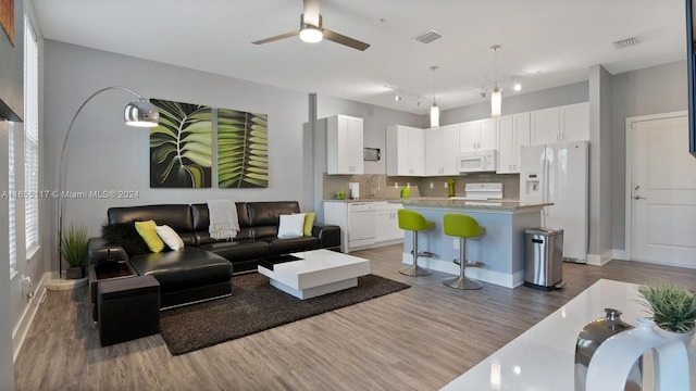 living room featuring ceiling fan and dark hardwood / wood-style floors