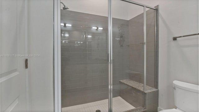 bathroom with an enclosed shower and toilet