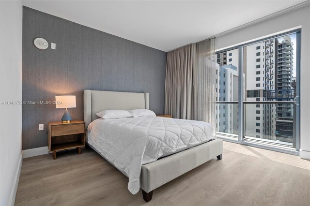 bedroom with multiple windows and wood-type flooring