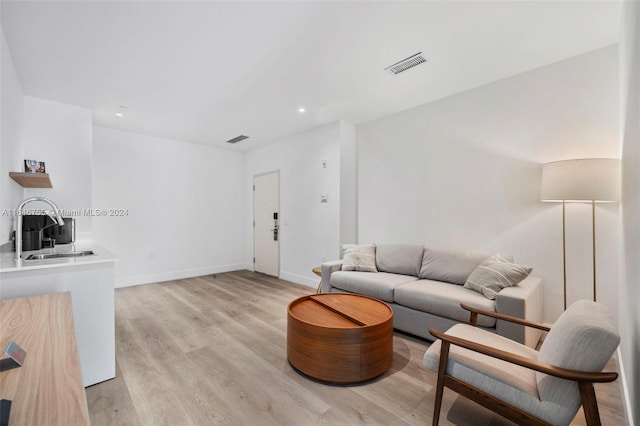 living room with light wood-type flooring and sink