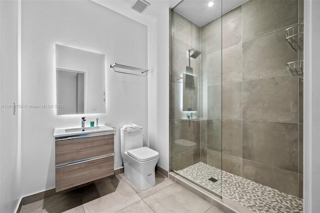 bathroom featuring vanity, toilet, tile patterned floors, and a shower with door