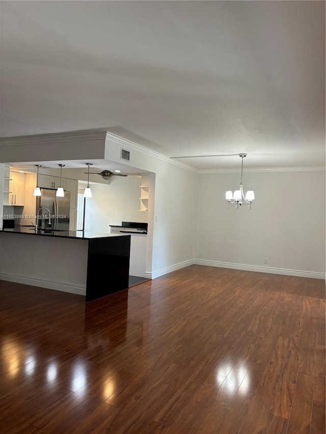 interior space featuring pendant lighting, stainless steel fridge, and dark wood-type flooring