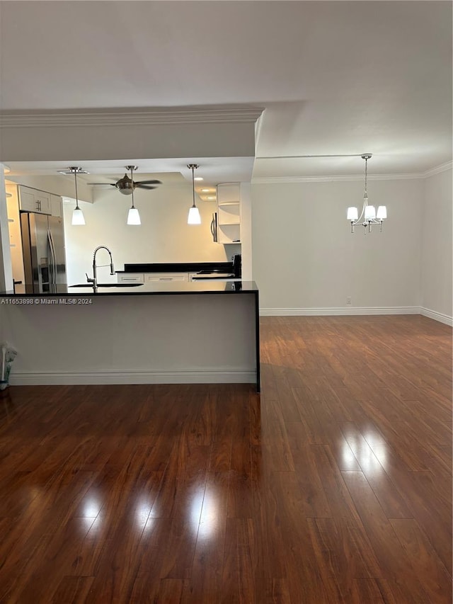 interior space featuring hanging light fixtures, ornamental molding, sink, dark hardwood / wood-style floors, and stainless steel fridge with ice dispenser