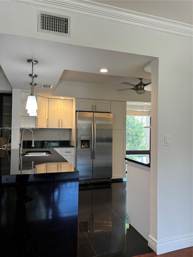 kitchen with ceiling fan, sink, stainless steel refrigerator with ice dispenser, pendant lighting, and ornamental molding