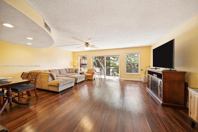 living room featuring a textured ceiling, ceiling fan, and dark hardwood / wood-style flooring