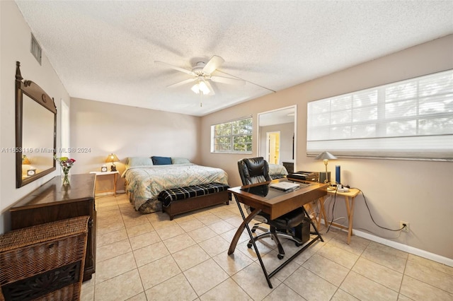 tiled bedroom featuring a textured ceiling and ceiling fan