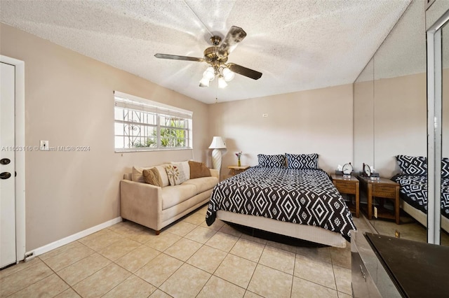 bedroom featuring a textured ceiling, light tile patterned flooring, and ceiling fan