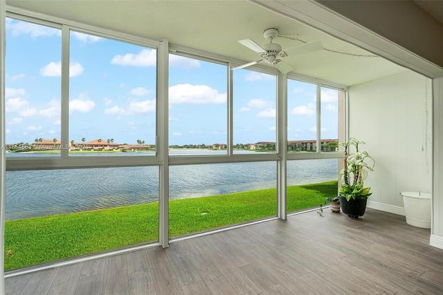 unfurnished sunroom with a water view, a ceiling fan, and a healthy amount of sunlight