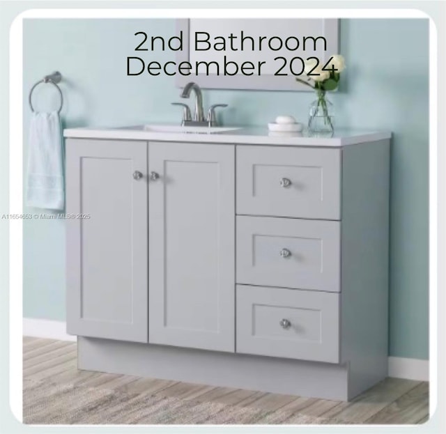 bar featuring sink, white cabinetry, and light wood-type flooring