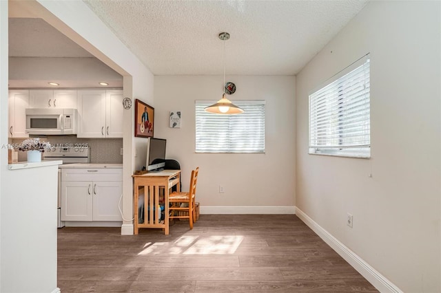 dining area with dark hardwood / wood-style floors and a textured ceiling