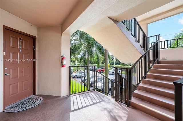 property entrance featuring a balcony and stucco siding