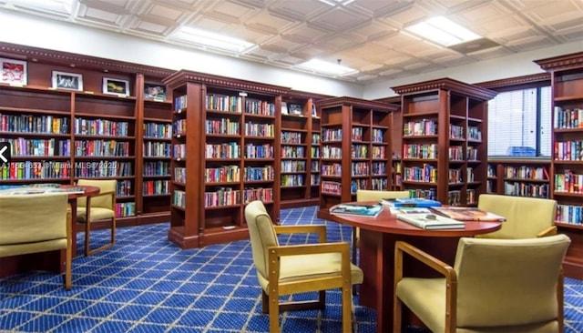 sitting room featuring an ornate ceiling and bookshelves