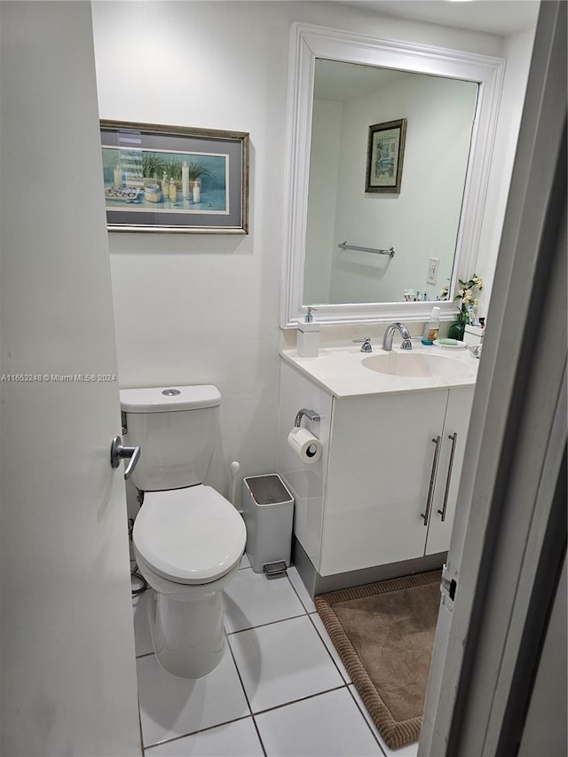 bathroom with tile patterned flooring, vanity, and toilet