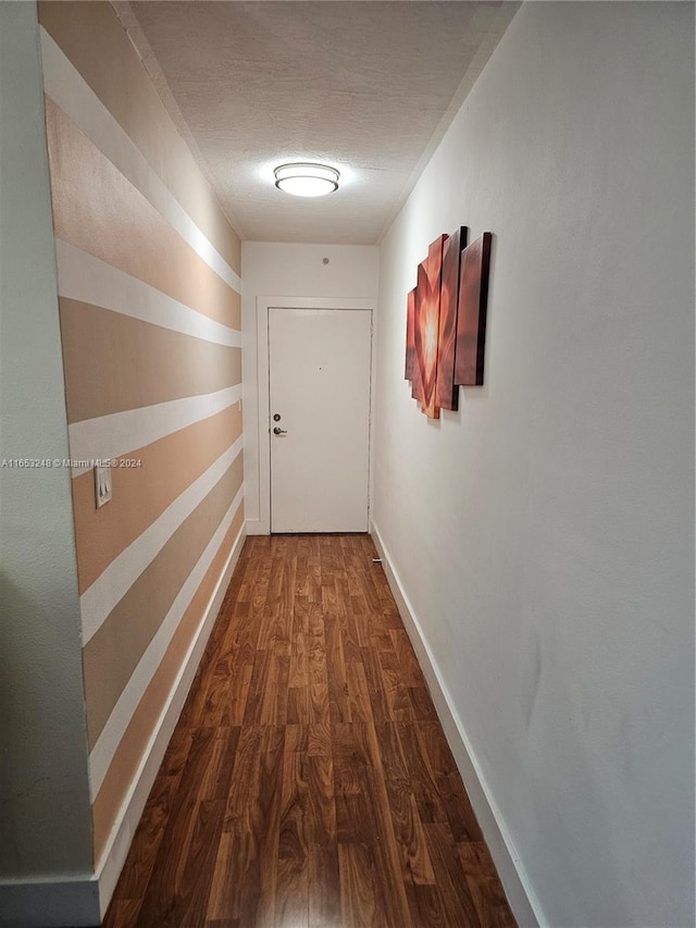 corridor featuring wood-type flooring and a textured ceiling