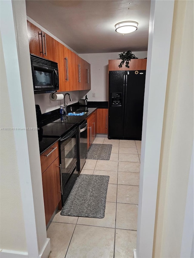 kitchen with light tile patterned flooring, sink, and black appliances