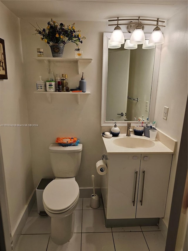 bathroom with tile patterned flooring, vanity, and toilet