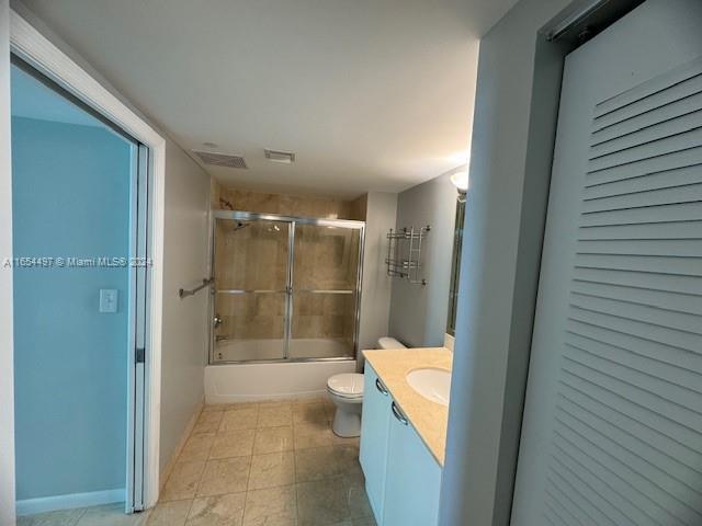 full bathroom featuring vanity, toilet, and combined bath / shower with glass door