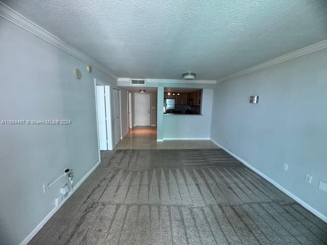 carpeted empty room with a textured ceiling and ornamental molding