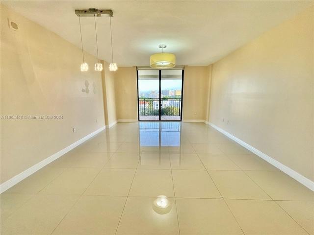 unfurnished room featuring a wall of windows and light tile patterned floors