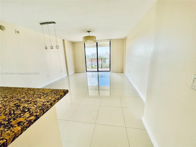 tiled empty room featuring expansive windows